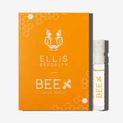 Petit flacon de parfum Bee 1,5 ml à côté de la carte porte-flacon Bee Eau de Parfum orange.