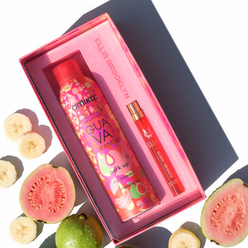 Coffret cadeau Amika x Ellis Brooklyn GUAVA GRANITA Shampooing sec Perk Up et GUAVA GRANITA Eau de Parfum 10 ml à côté de goyaves entières et tranchées et de morceaux de banane sur fond blanc