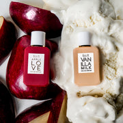 Apple Love 7.5ml Eau De Parfum Mini Dabber on sliced apples next to Vanilla Milk 7.5ml Eau De Parfum Mini Dabber on vanilla ice cream, on white background.