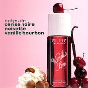 Brume Parfumée VANILLA SIN 240ml surmontée d'une cerise et entourée de 4 cerises empilées, une gousse de vanille appuyée contre le flacon et un tas de crème fouettée avec 4 noisettes sur un fond dégradé rose et blanc avec un texte noir indiquant 