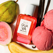 GUAVA GRANITA Eau de Parfum 50ml est posé à côté d'une goyave, d'une goyave coupée en deux, d'une banane tranchée, de deux boulettes de granita rose et de 3 gousses de vanille sur un fond blanc
