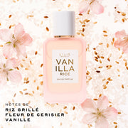 Flacon Ellis Brooklyn Vanilla Rice Eau de Parfum 50 mL en verre rose pâle délicat avec un bouchon blanc, posé au centre sur un fond de grains de riz blancs et bruns et de fleurs roses. Le texte en bas à gauche indique 'NOTES DE RIZ GRILLÉ, FLEUR DE CERISIER, VANILLE'.