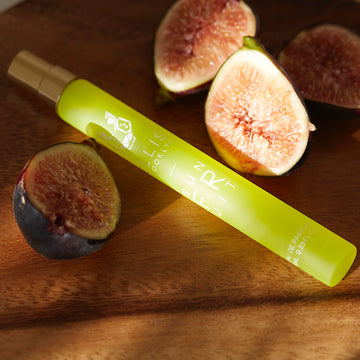 Sun Fruit 10ml Eau De Parfum Travel Spray on wooden table with figs.