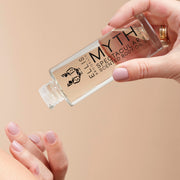 Model with nude nail polish wearing gold rings holding Model holding Myth 95ml Spectacular Scented Body Oil with out cap in one hand while dispensing product onto other hand.