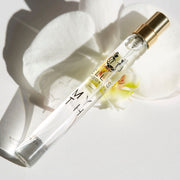 Myth 10ml Eau De Parfum Travel Spray resting on white orchid flower on white background.